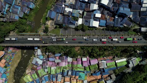 top view of cars on the road in the middle of two colorful villages - jodipan "rainbow" village and the blue city - malang, east java - indonesia