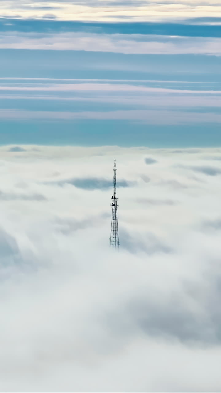 Aerial drone view of an utility pole in the clouds. Vertical