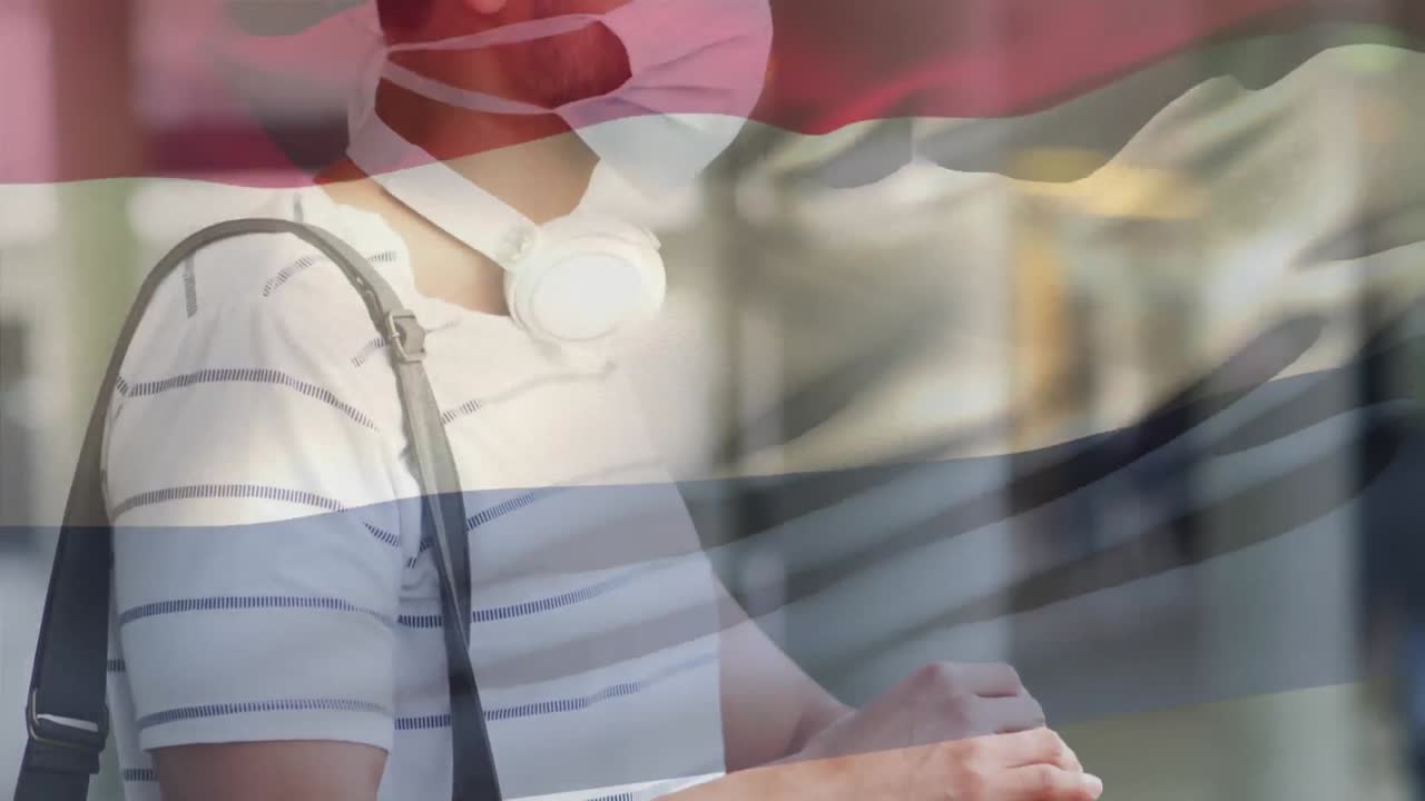 코로나19 전염병 기간 동안 마스크를 쓰고 있는 남성 위에 날아다니는 네덜란드 국기의 애니메이션