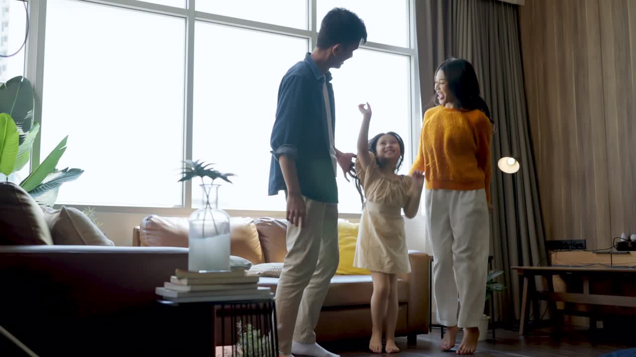 행복한 순간 젊은 아시아 가족 아버지 어머니 딸 행복한 시간을 보내고 집에서 거실에서 함께 춤을 추고 소셜 미디어 활동 웃음과 미소와 신선함으로 재미있는 가족 춤