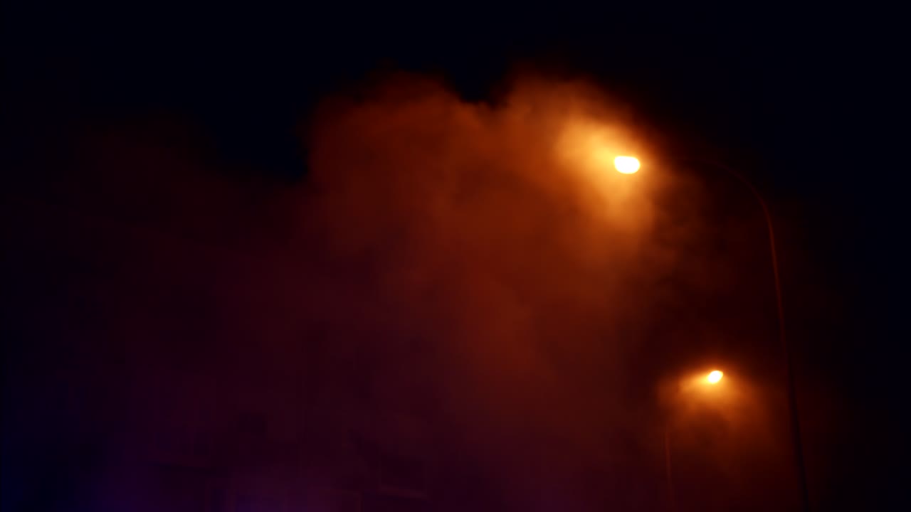 Orange Glowing Smoke and Streetlights in the Dark Night