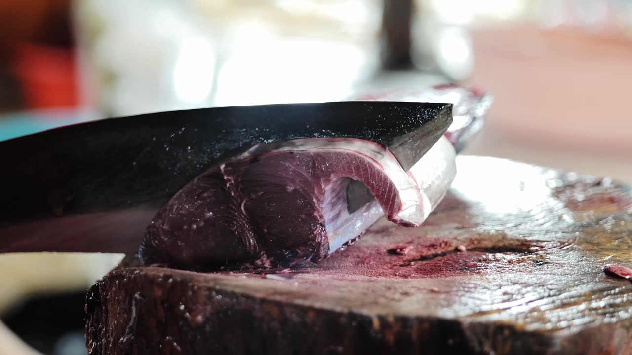 pesce tagliato con attrezzo pesante su tagliere di legno nel Vecchio Mercato Pubblico di Palawan