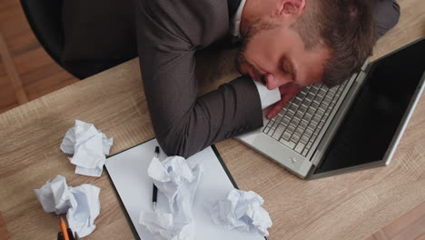 aburrido cansado somnoliento hombre de negocios quedándose dormido después de un trabajo de rutina en una computadora portátil en el escritorio de la oficina