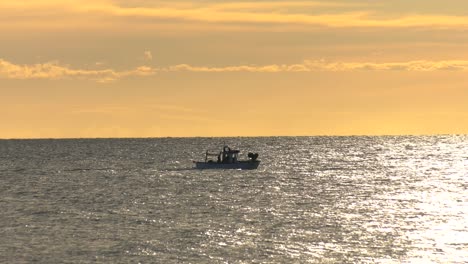 pequeños barcos pesqueros españoles en un mar plateado al amanecer, mediterráneo