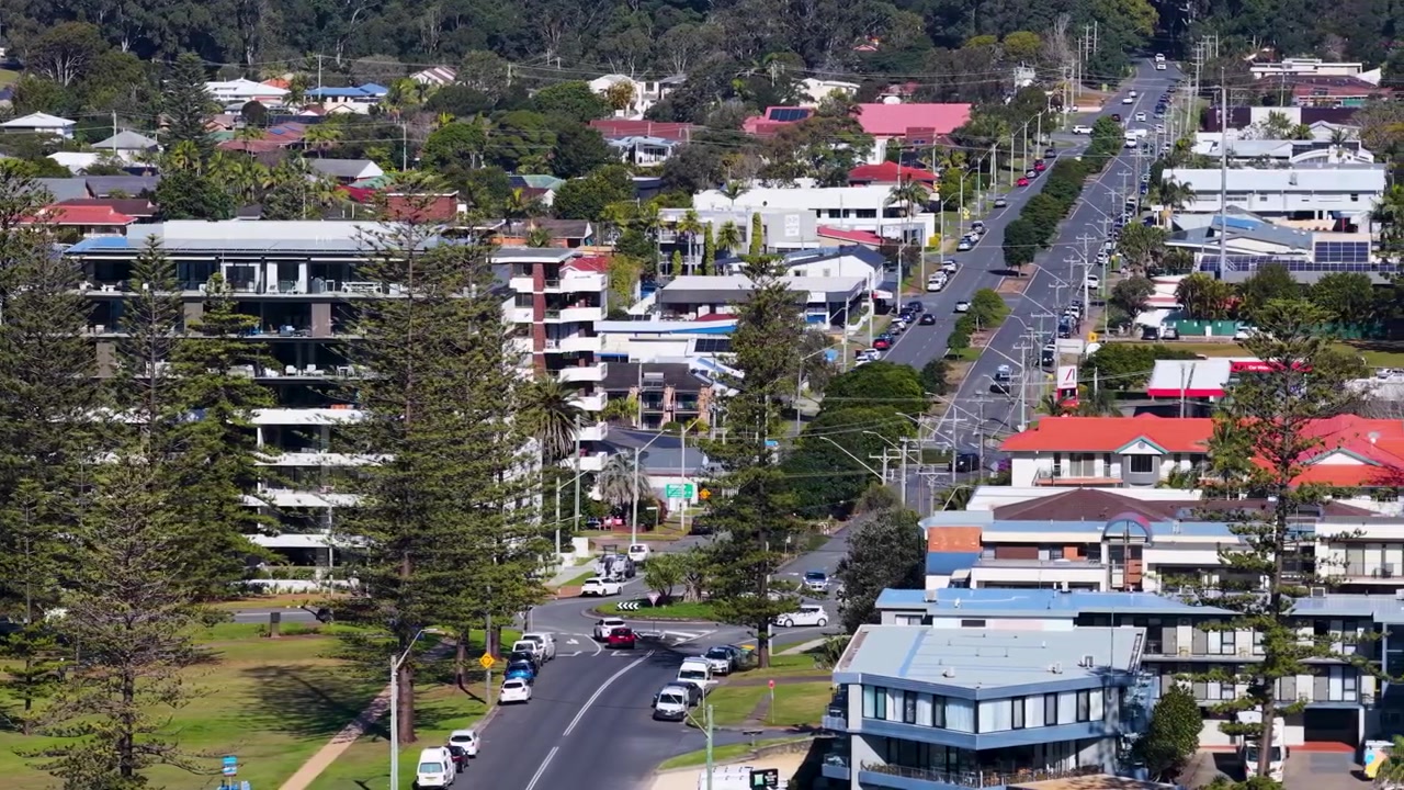 Ripresa aerea con drone di appartamenti residenziali e traffico su strade suburbane a Nelson Bay, Australia
