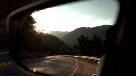 view of mountain road on the side mirror of a car