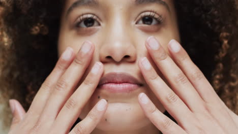 biracial woman with dark hair touching face, slow motion