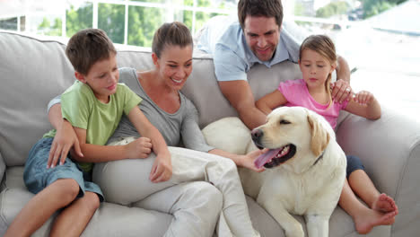 cute family relaxing together on the couch with their dog