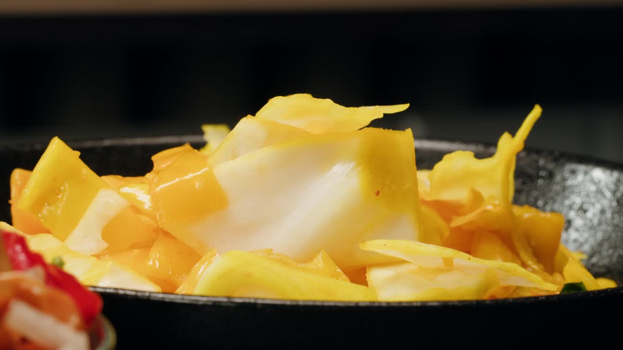 Close-up of fermented yellow cabbage on plate. Preservation of vegetables in glass jars. Fermentation preserved vegetables. Sauerkraut with spices.