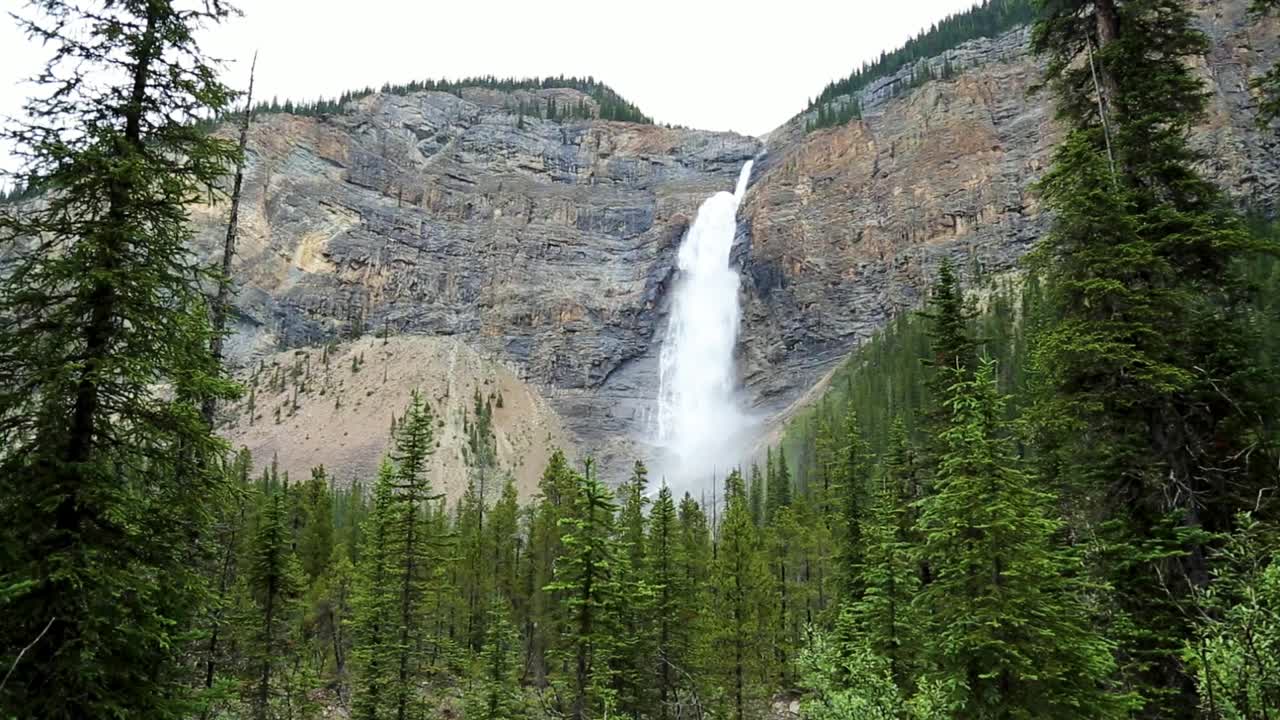 impresionante vista panorámica estática de enormes cascadas que caen por la cordillera rocosa