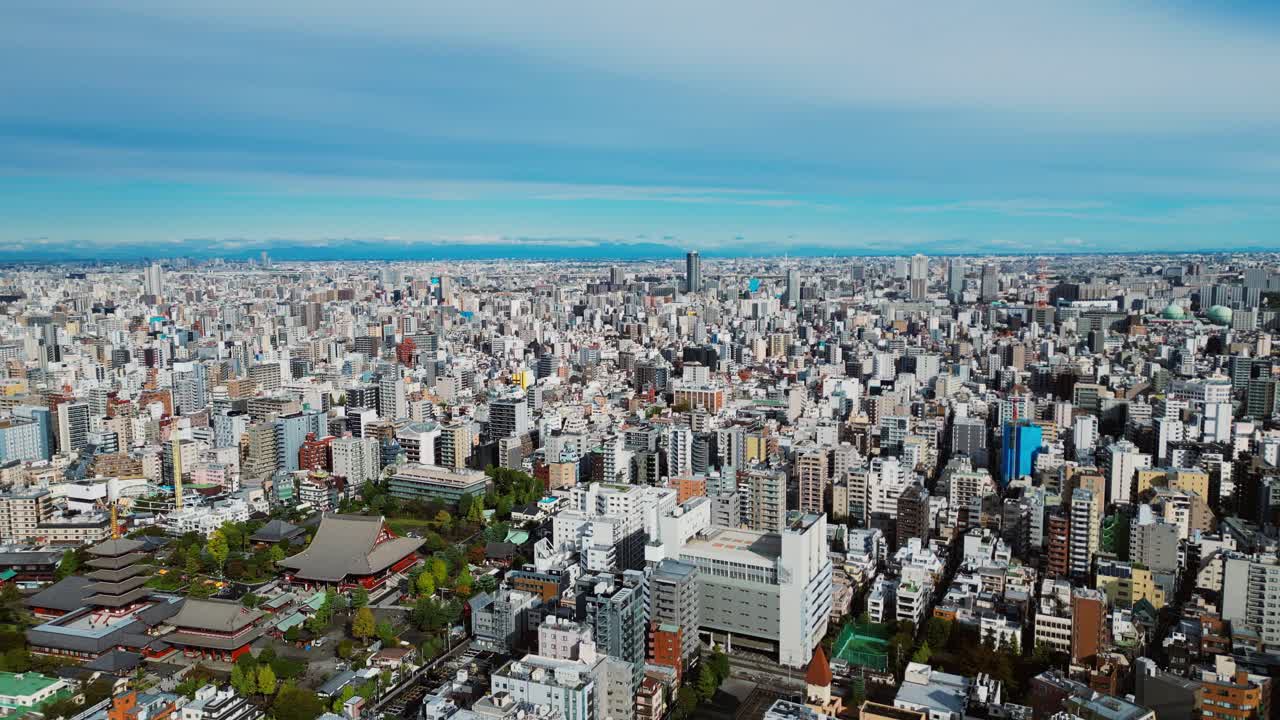 Slow forward drone shot reveals Asakusa temple in balance with modern Tokyo city