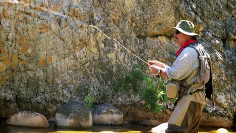 fisherman fly fishing in river