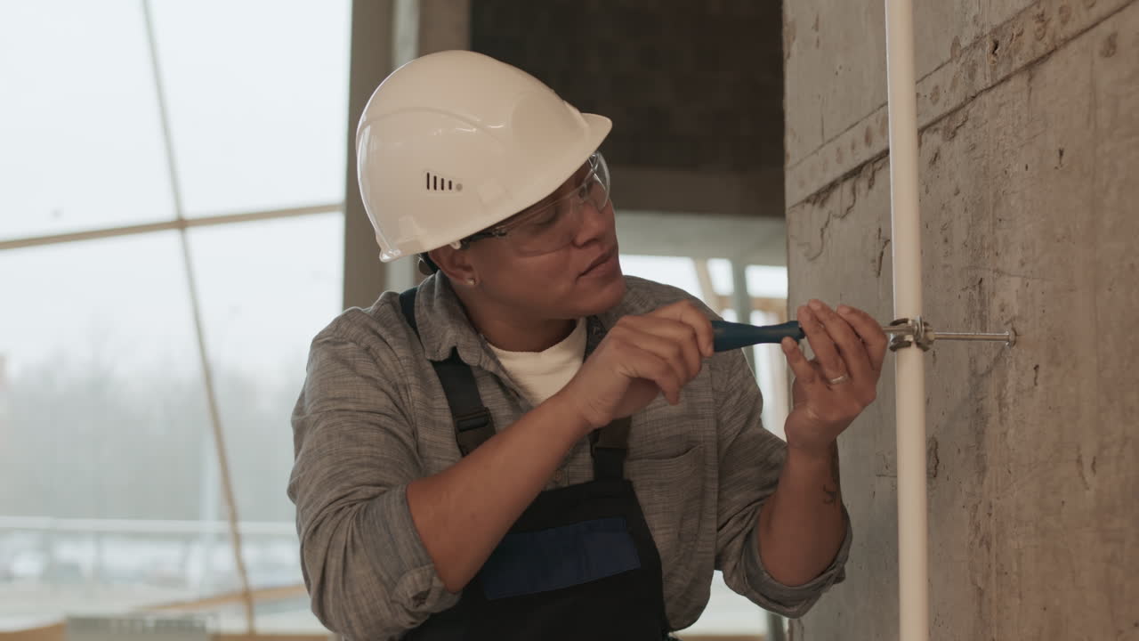 mujer atornillando en el tubo a la pared