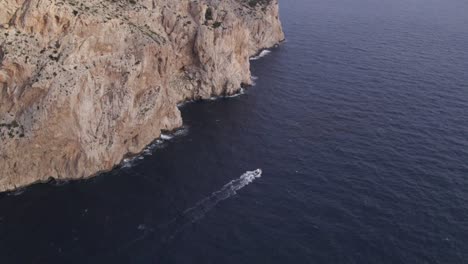 trawler fishing boat cruising on ocean near cap formentor mallorca, aerial