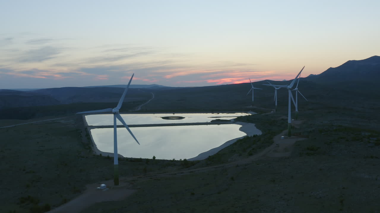 Aerial View of Wind Farm with Reservoir at Sunset