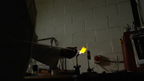 Close-up-of-male-worker-blowing-glass-in-glass-factory-4k