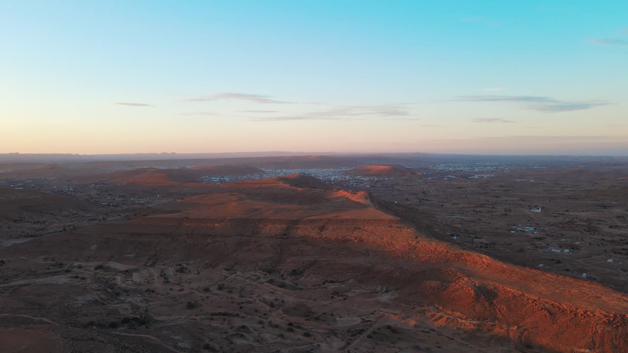 Aerial view of Ksar Jarrat, Tunisia at sunset. Rolling hills and desert landscape.