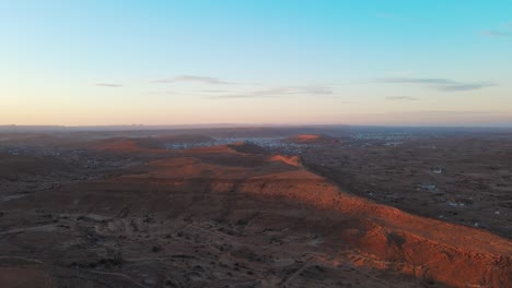aerial view of ksar jarrat, tunisia at sunset. rolling hills and desert landscape.