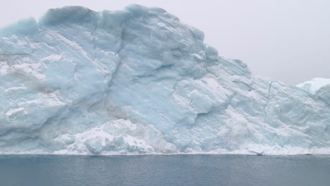 Aquamarinblauer-Eisberg-Schwimmt-An-Einem-Bewölkten-Tag-Auf-Dem-Ozean