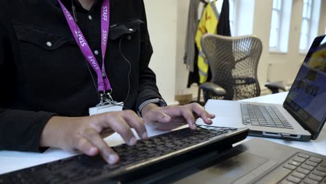 Male-In-typing-on-keyboard-within-an-indoor-office-setting,-illustrating-the-notion-of-digital-labour-and-managing-tasks