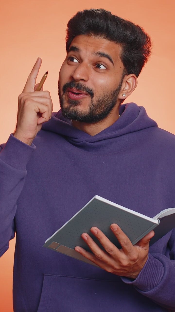 Man making notes writing down thoughts with pen into notepad notebook diary to do list good idea