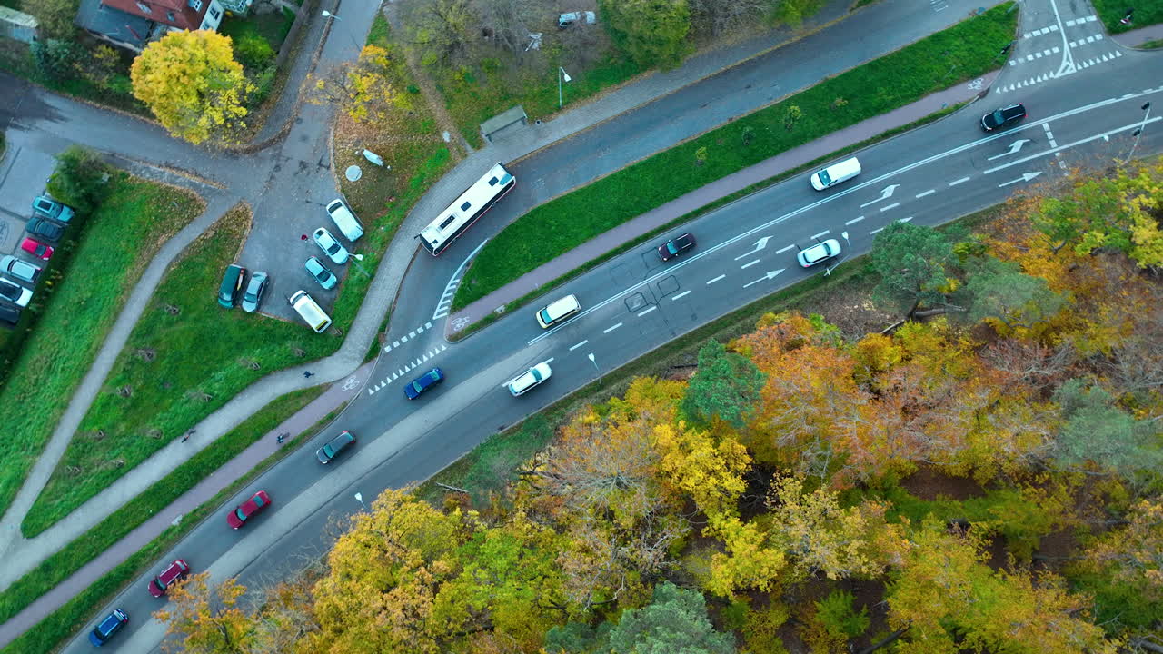 Drone shot of a parking area, forest, and roadway creating contrasting urban–nature patterns