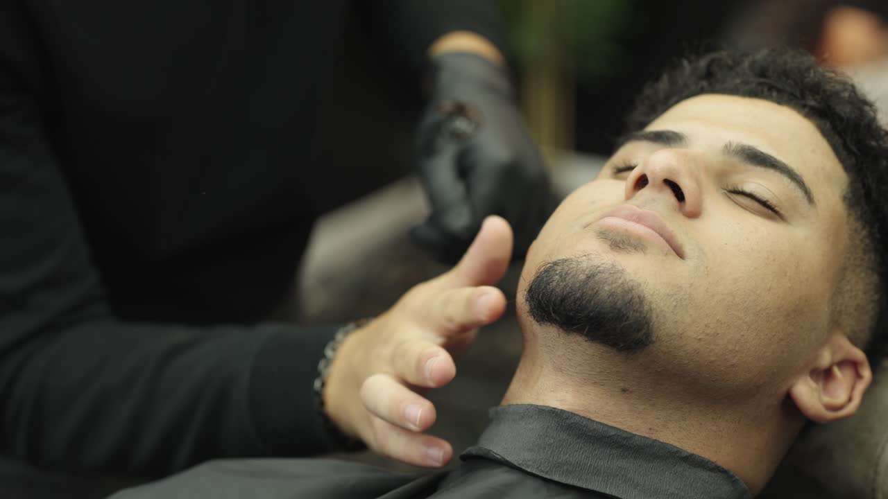 Mand, der bliver barberet i en barbersalon