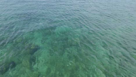 clear blue ocean waters seen from above with gentle waves creating a serene, peaceful scene