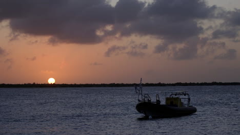 Sunset-with-boat-near-coast-of-Bonaire,-the-Antilles,-the-Caribbean