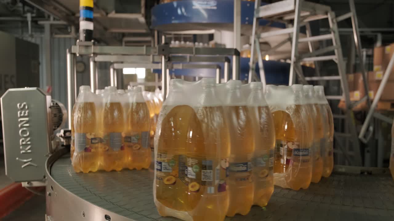 máquina moderna de ataduras y transporte para la línea de envasado en la planta de bebidas