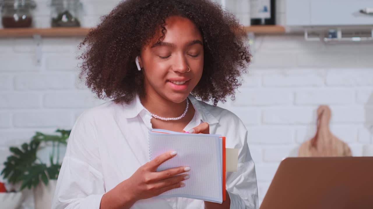 Young african american woman passes online interview via laptop sits at kitchen