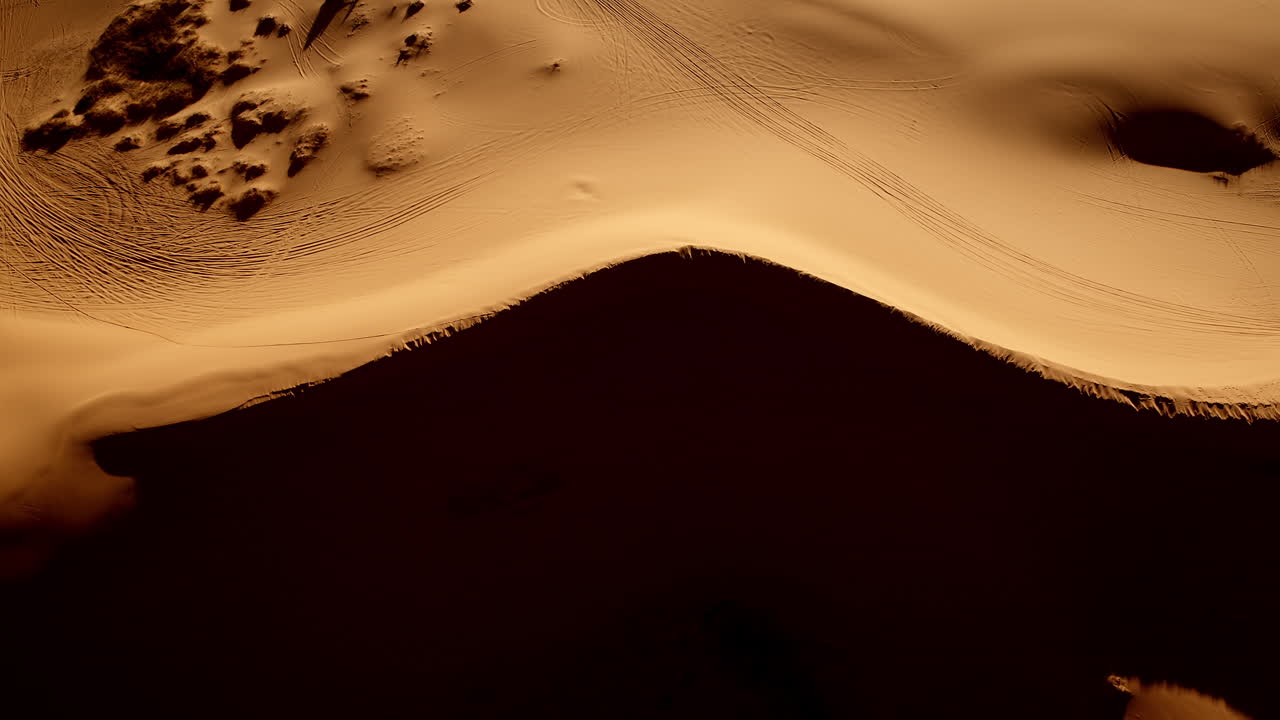 Overhead drone view showcasing the surreal colors and flowing forms of pink dunes in southern Utah.