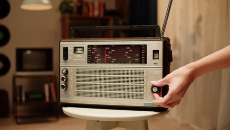 person adjusting an old vintage radio