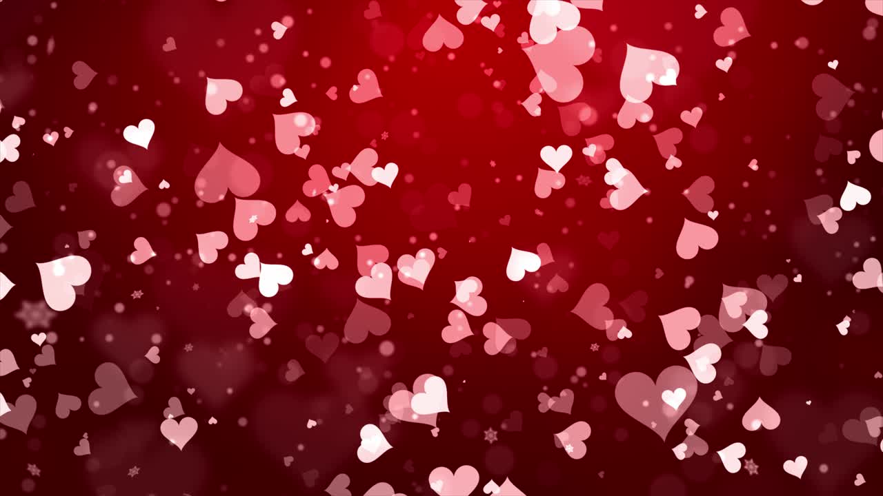 románticas partículas rojas brillantes y en forma de corazón volando sobre un fondo de bucle oscuro.
