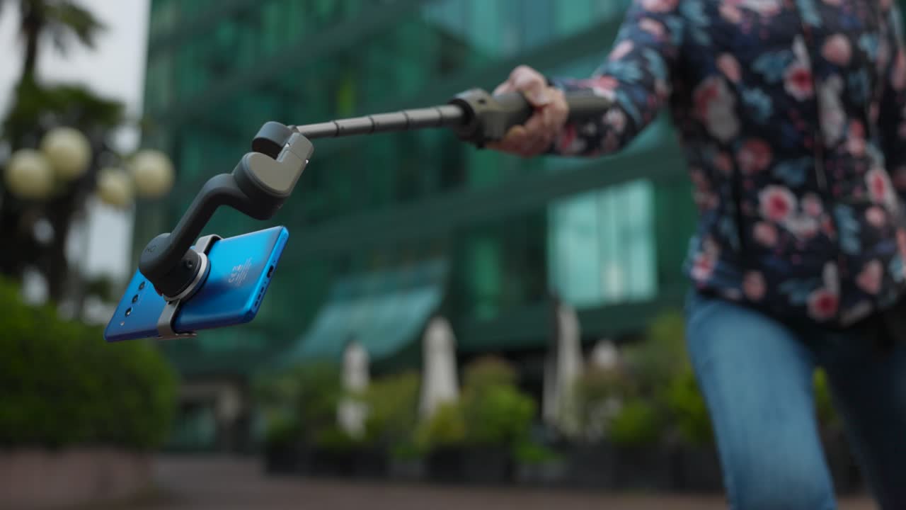 vista de cerca del estabilizador gimbal móvil osmo con un teléfono inteligente azul