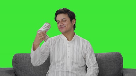 happy indian man using money as fan green screen