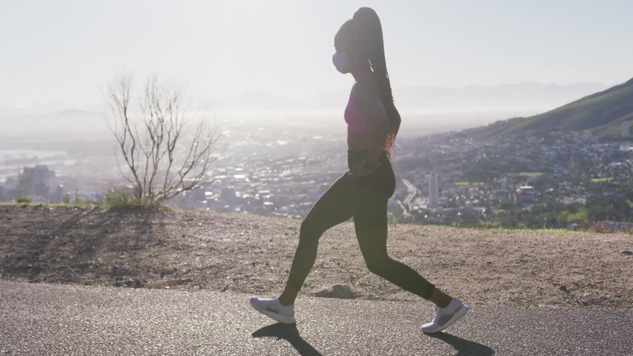 아프리카계 미국인 여성이 고속도로에서 다리를  ⁇ 고 얼굴 마스크를 쓰고 있습니다.