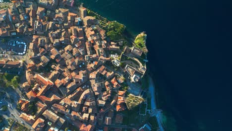 a stunning aerial shot of malcesine’s medieval old town—narrow alleys, terracotta roofs, and the deep blue of lake garda blending into a perfect composition.