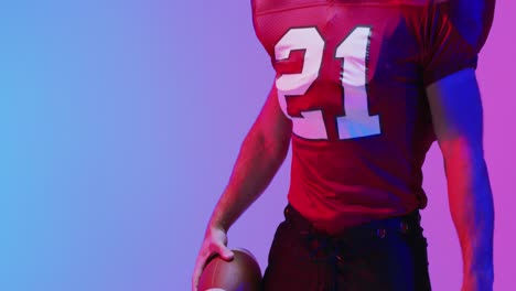 Video-of-caucasian-american-football-player-with-copy-space-over-neon-purple-background