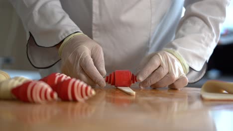 a french pastry chef rolls red croissant dough on the table