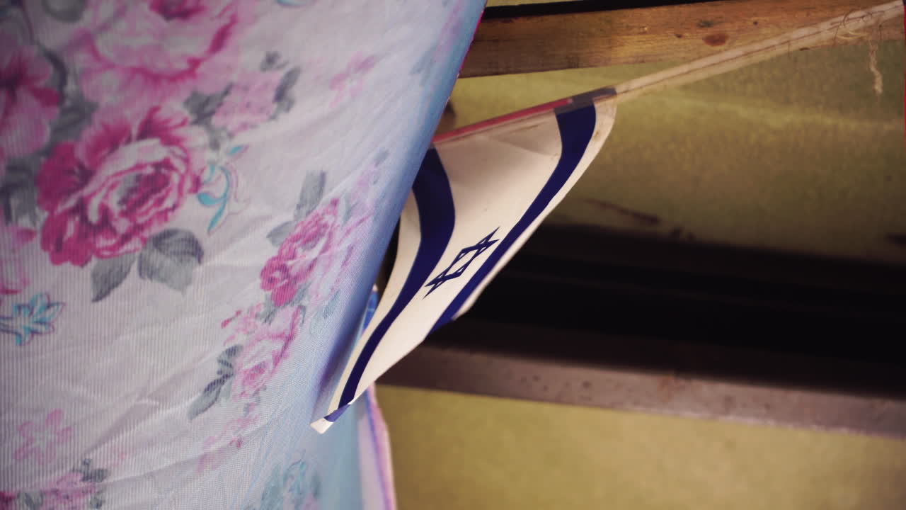 이스라엘의  ⁇ 발이 바람에 흔들리는 시설 내부의 시트  ⁇ 에 매달려 있습니다.