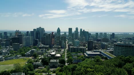 4K-Cinematic-urban-drone-footage-of-an-aerial-view-of-buildings-and-skyscrapers-in-the-middle-of-downtown-Montreal,-Quebec-on-a-sunny-day