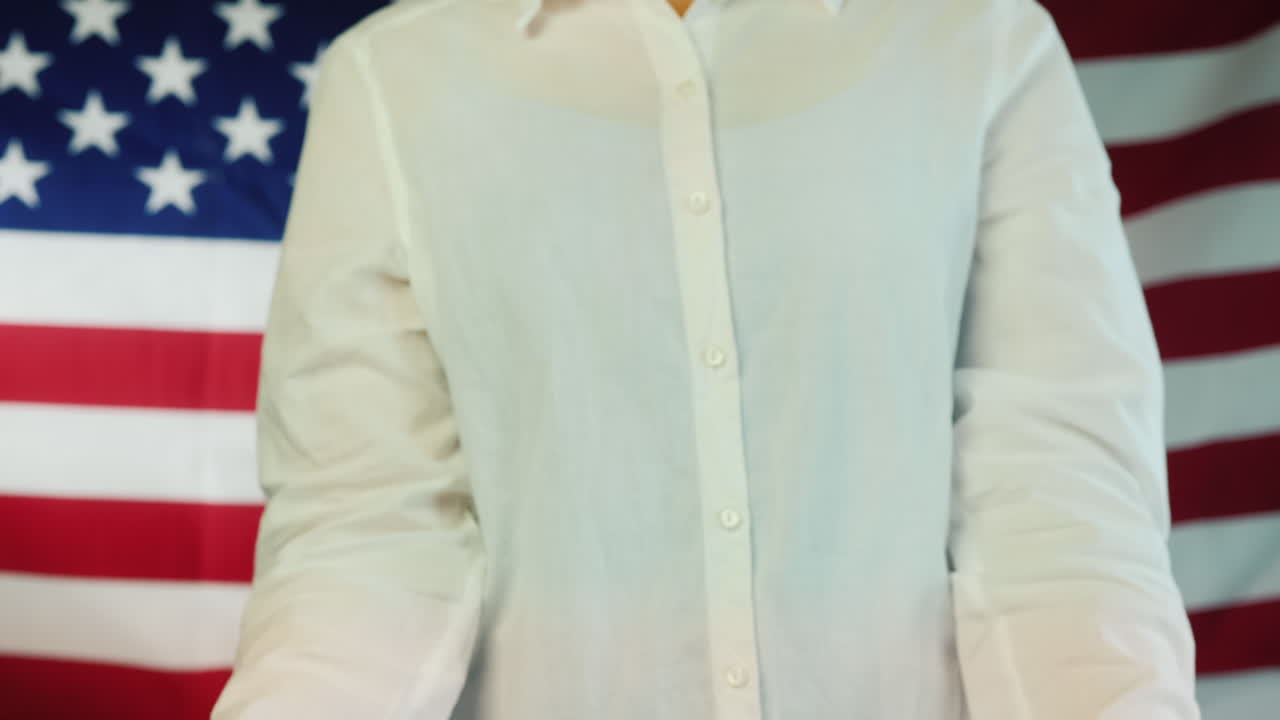 mujer sostiene un cartel que dice que el silencio es violencia en el fondo de la bandera americana