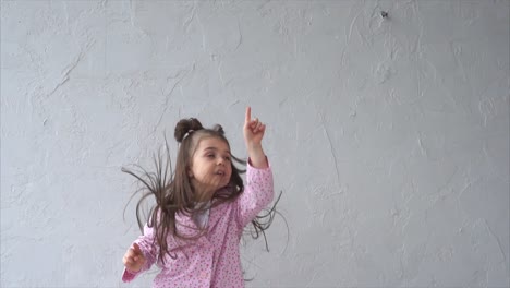 happy little girl jumping in pink pajamas