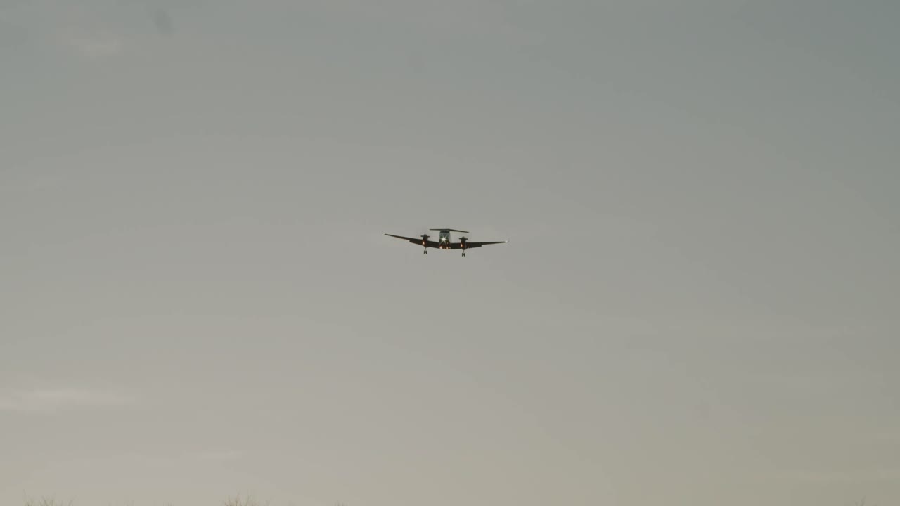 큰 공기 프로펠러 비행기가 해가 지면 낮은 비행을 한다