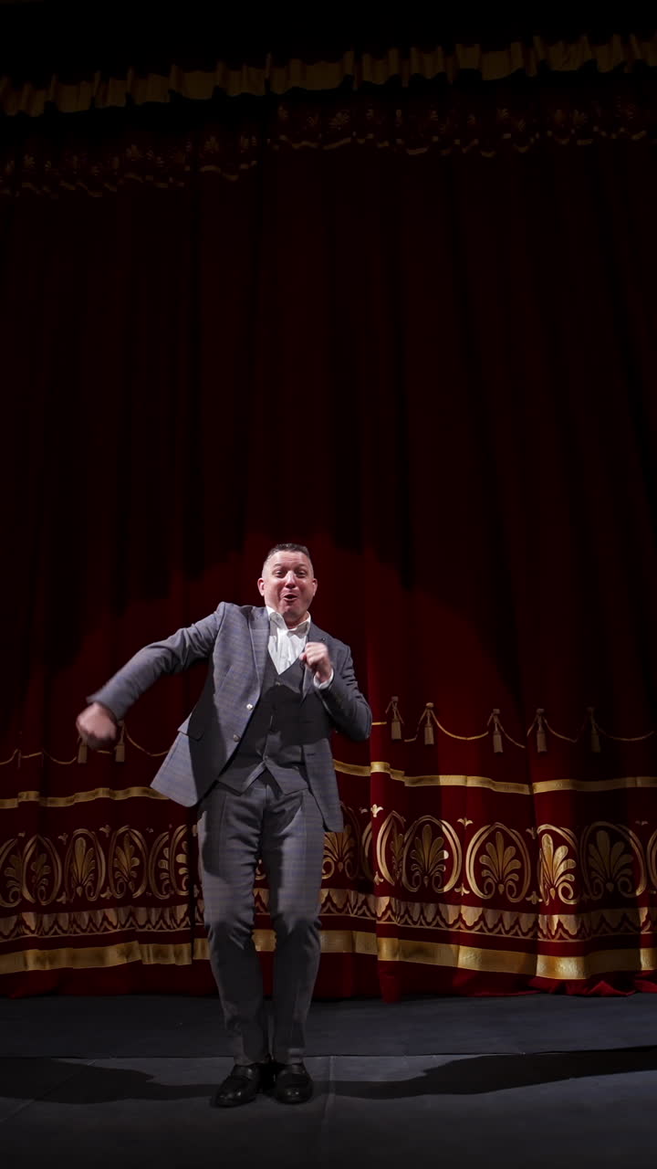 Portrait of a comedian talking. Cheerful actor in suit telling funny stories and gesticulating a lot. Joyful man performing on stage. Vertical video