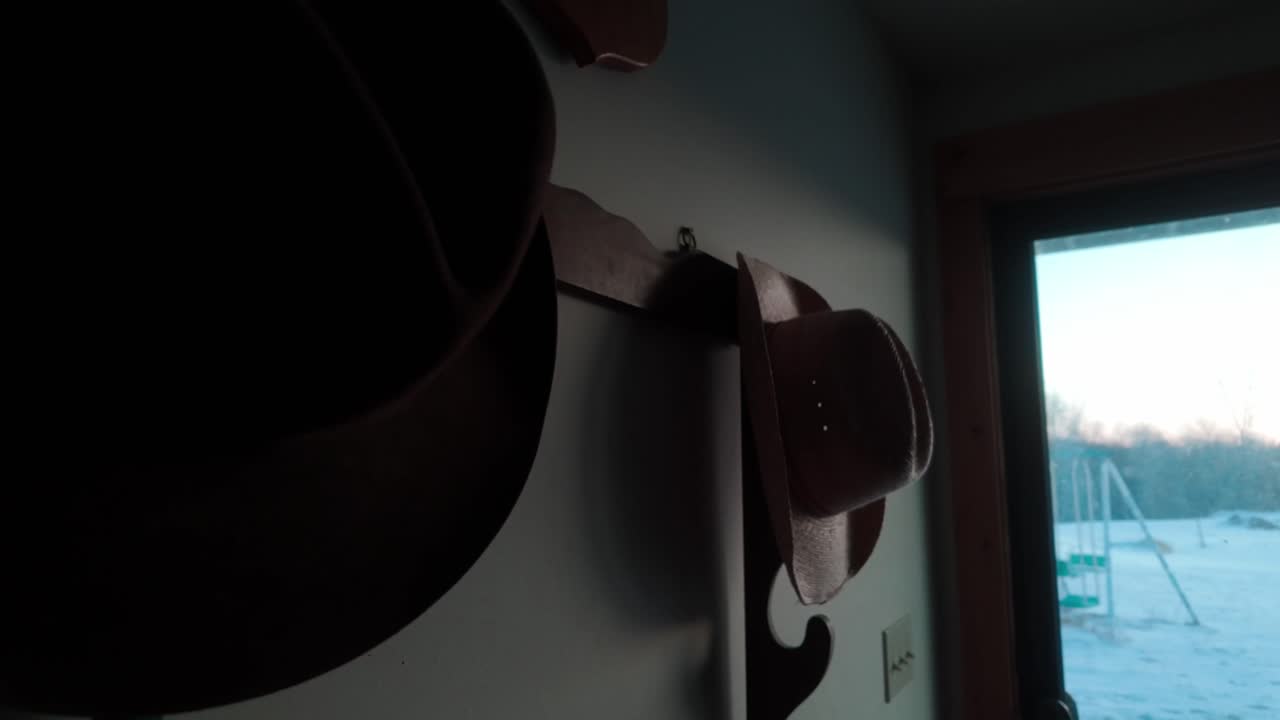 Cowboy hats hanging on a wall in a country home in winter