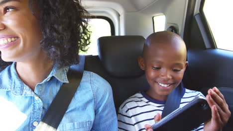 joven madre negra con un niño en un coche que va en un viaje por carretera