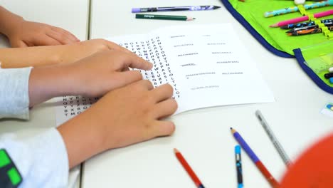 los niños colaboran en un rompecabezas de búsqueda de palabras en un entorno de clase