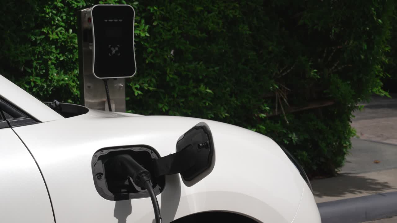 Şarj istasyonunda elektrikli araba park etme ve şarj etme konusunda ilerici konsept.
